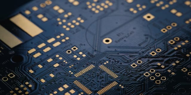 Close-up of a green circuit board with copper traces, representing low-level hardware optimization.