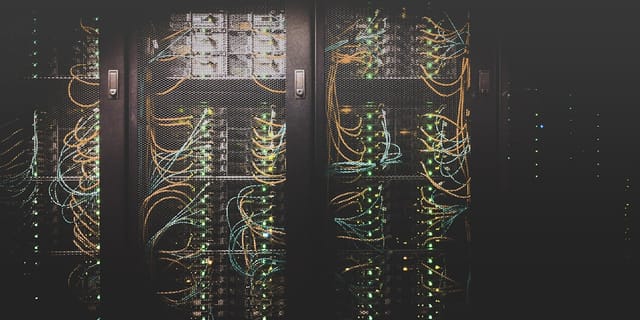 Row of GPU server racks with illuminated status lights in a data center